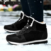 Men Waterproof Winter Boots – Warm Plush Non-Slip Snow Shoes in black worn in the snow on a winter day.