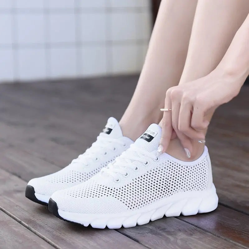 Women Mesh Sneakers – Lightweight Breathable Casual Shoes worn by a person sitting on a wooden floor.