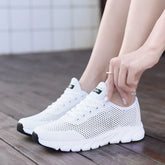 Women Mesh Sneakers – Lightweight Breathable Casual Shoes worn by a person sitting on a wooden floor.